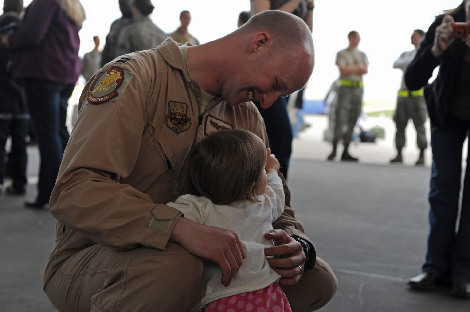 SPANGDAHLEM AIR BASE, Germany – Capt. John Cotman, 81st Fighter Squadron A-Flight commander, embraces his daughter on Ramp 3 here April 13. Family and friends waited at Hangar 3 to welcome home more than 70 Airmen from a deployment with 81st Fighter Squadron to Bagram Airfield, Afghanistan, who had been providing close-air support during Operation Enduring Freedom. (U.S. Air Force photo by Airman 1st Class Matthew B. Fredericks/Released)