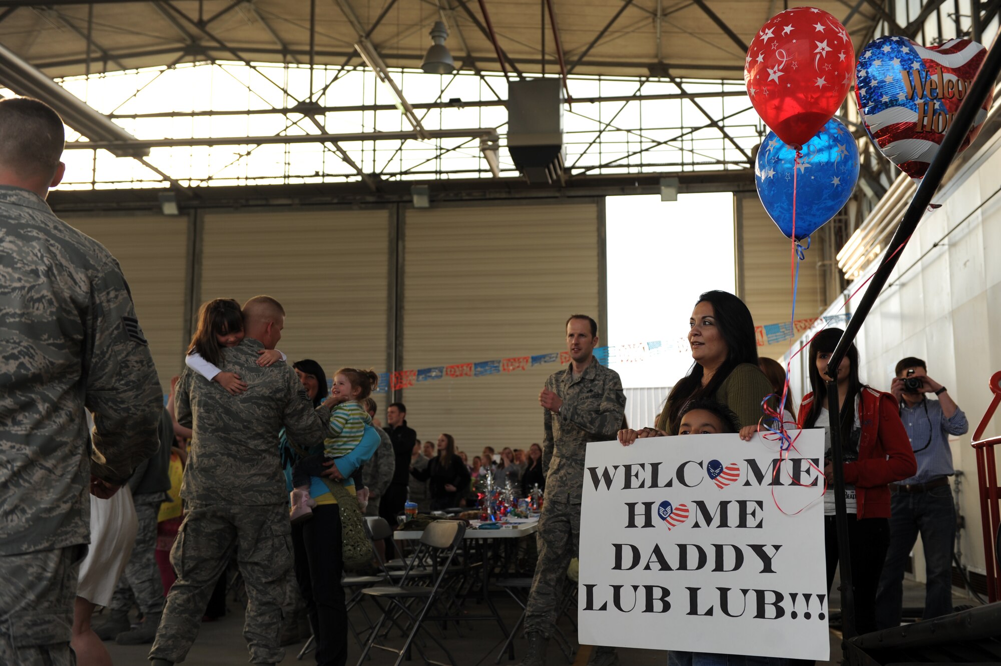 SPANGDAHLEM AIR BASE, Germany – Rene Bernal holds up a sign while waiting with his mother, Patricia, to welcome home his father, Staff Sgt. Christopher Bernal, 81st Aircraft Maintenance Unit weapons load crew team chief, on Ramp 3 here April 13. Family and friends waited at Hangar 3 to welcome home more than 70 Airmen from a deployment with 81st Fighter Squadron to Bagram Airfield, Afghanistan, who had been providing close-air support during Operation Enduring Freedom. (U.S. Air Force photo by Airman 1st Class Matthew B. Fredericks/Released)
