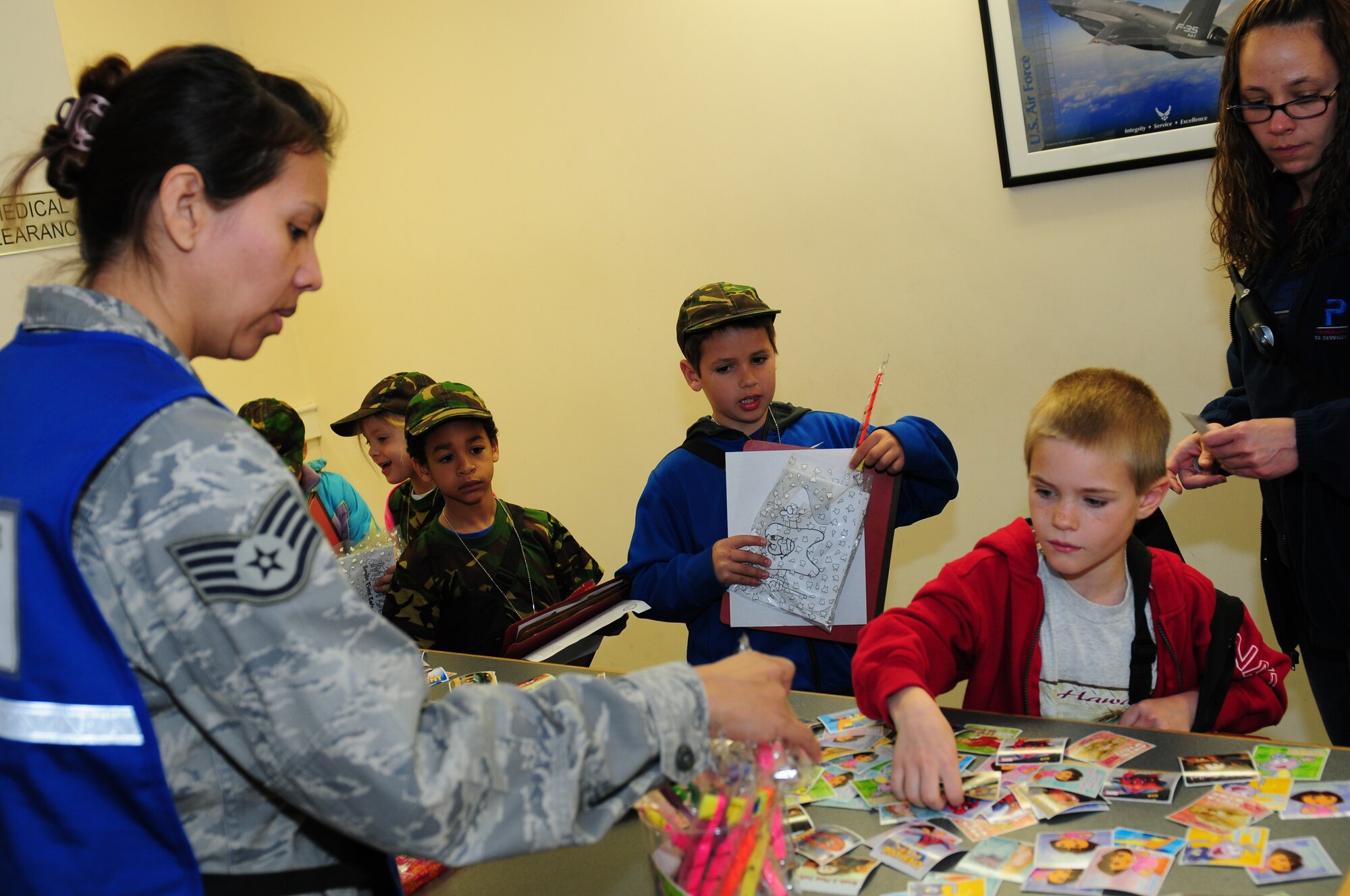 ROYAL AIR FORCE LAKENHEATH, England – Children from Lakenheath Elementary School receive stickers in place of shots in the medical clearance portion of a simulated personnel deployment function at the Installation Deployment Readiness Center April 13, 2011. The mock deployment line is designed to provide children with a better understanding of what their parents experience as they prepare for deployment. (U.S. Air Force photo by Airman 1st Class Cory D. Payne)