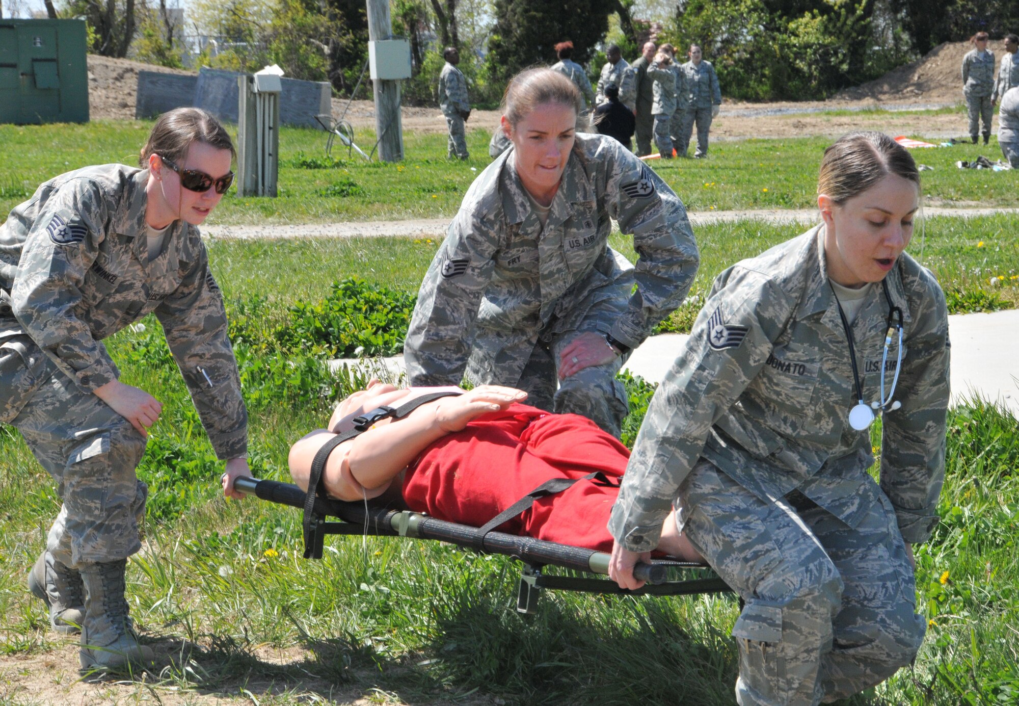 From right to left, 512th Aerospace Medicine Squadron Medical Readiness Technicians Staff Sgt. Christina Donato, Staff Sgt. Julia Fry and Staff Sgt. Tina Burwinkel transport a patient during the mass casualty exercise at Dover Air Force Base, Del., April 13, 2012. The exercise was designed to maintain members' currency while evaluating communication skills, medic field skills and emergency-response time. (U.S. Air Force photo by Capt. Marnee A.C. Losurdo)