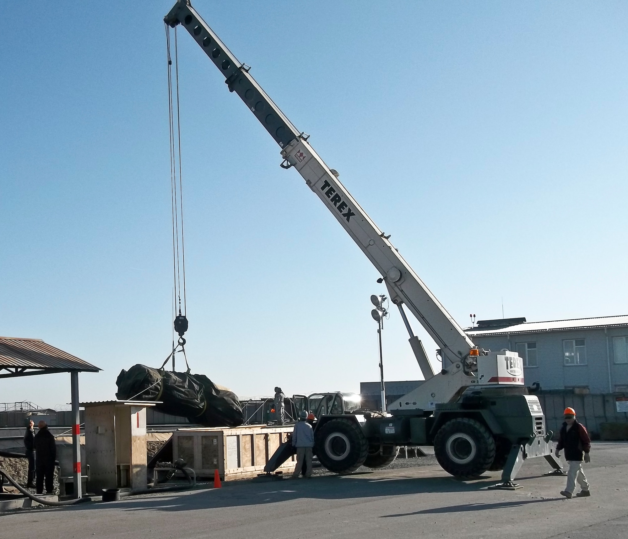 Members of the 376th Expeditionary Civil Engineer Squadron horizontal shop operate a crane to hoist a fuel bladder into place March 27, 2012, during a fuel tank and berm liner change at the Transit Center at Manas, Kyrgyzstan. The 1,200-pound berm liner and 7,500-pound fuel tank took four days to change; the 376th ECES removed the old ones from the containment area.  (U.S. Air Force courtesy photo)