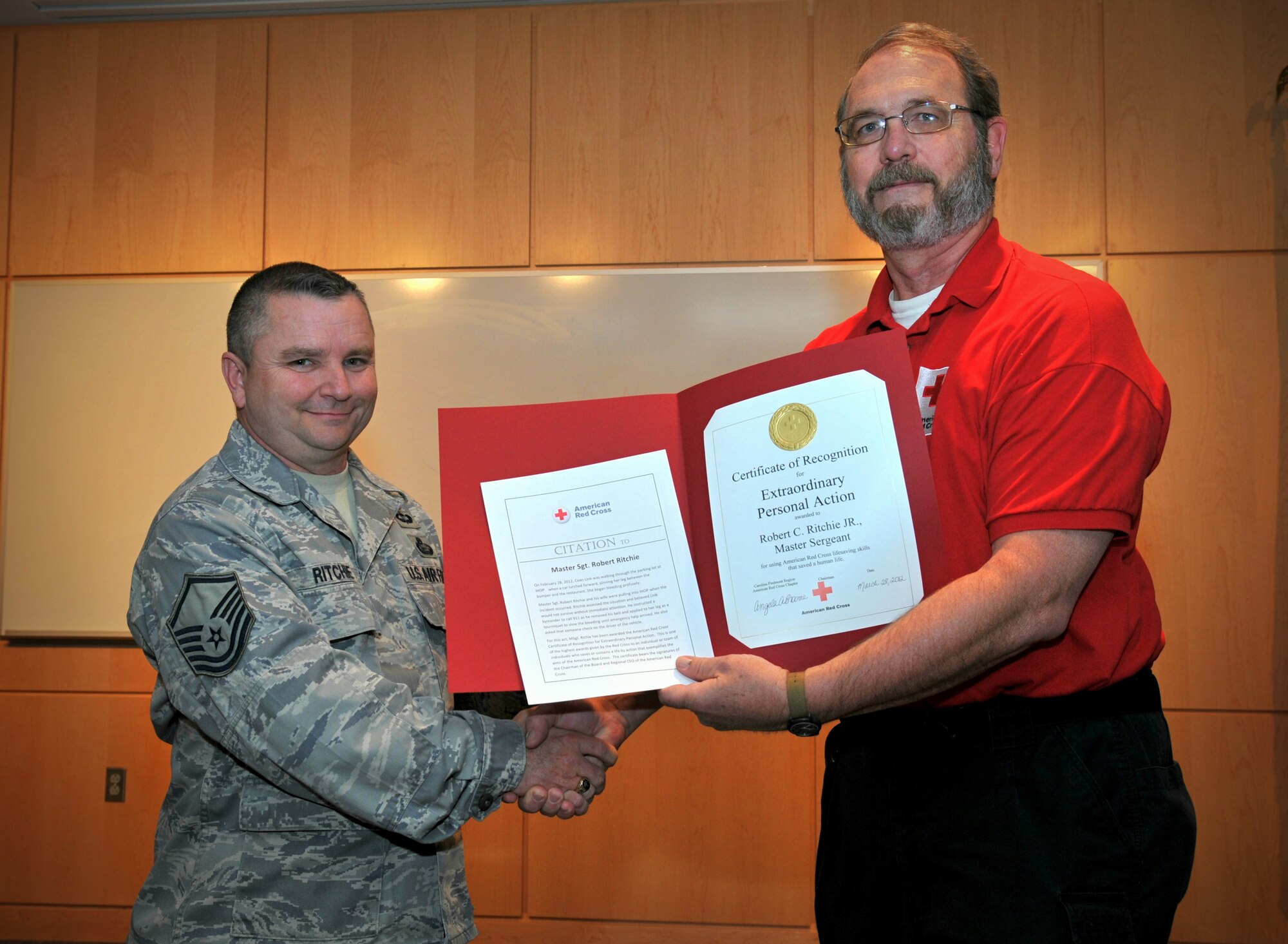 Master Sgt. Robert C. Ritchie of the 118th Air Support Operations Squadron, North Carolina Air National Guard is awarded the American Red Cross Certificate of Recognition for Extraordinary Personal Action by Tim Patton of the Carolina Piedmont Region of the American Red Cross. In early March Ritchie provided medical attention to a woman pinned between a vehicle and a wall. The Certificate of Recognition for Extraordinary Personal Action is one of the highest awards given by the American Red Cross.