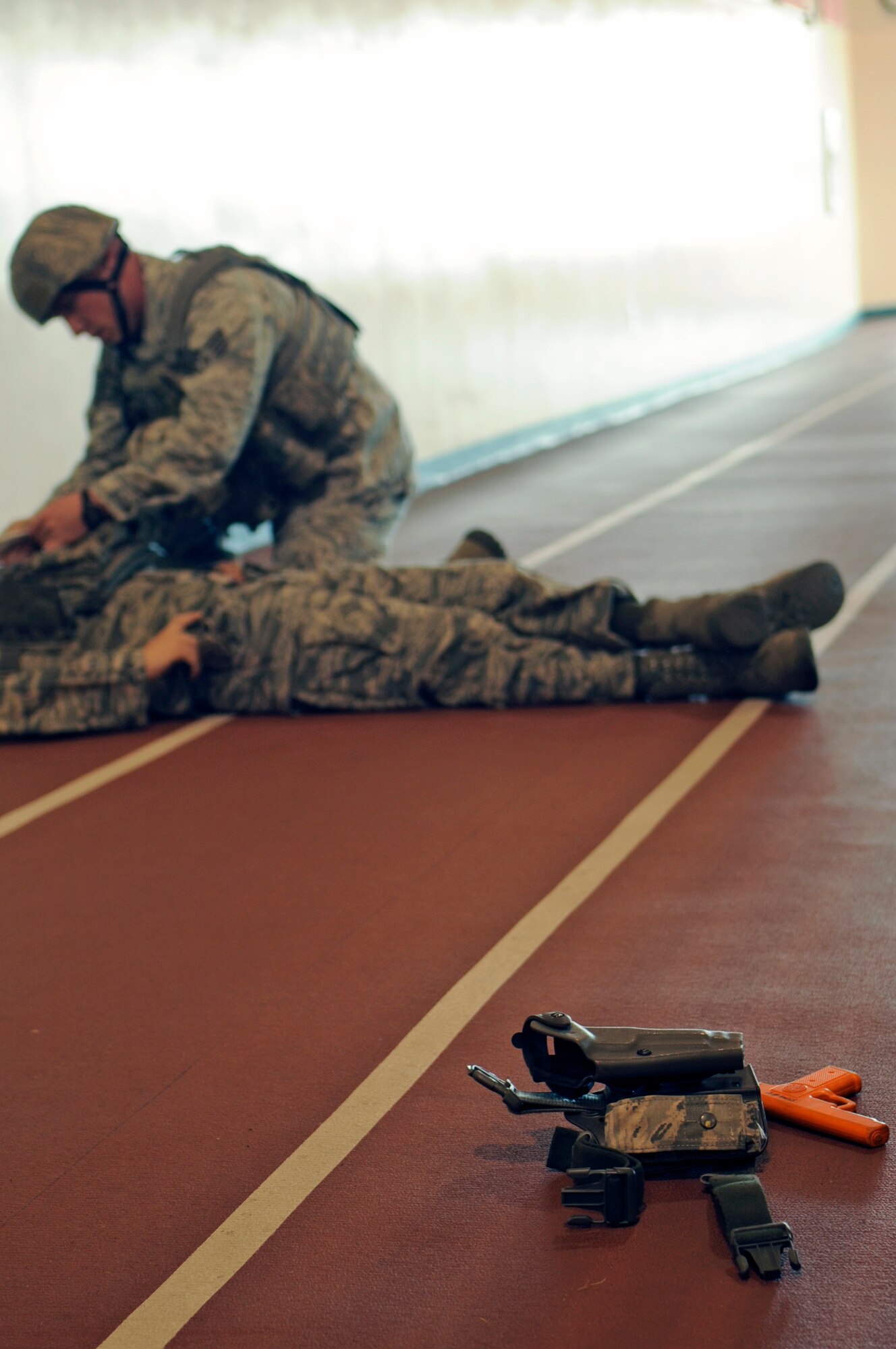 An 8th Security Forces Squadron Airman checks the vitals of a simulated active shooter perpetrator at the Wolf Pack Fitness Center, April 16, 2012. The 8th Fighter Wing is currently undergoing a Consolidated Unit Inspection by Pacific Air Forces Inspector General team members, who test the base’s ability to respond to crises such as an active shooter. (U.S. Air Force photo/Senior Airman Jessica Hines) 