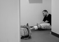 A simulated gunshot victim waits for medical responders after receiving self-aid and buddy care from 8th Security Forces Squadron Airmen at the Wolf Pack Fitness Center, April 16, 2012. Pacific Air Forces Inspector General team members are testing the 8th Fighter Wing ability to conduct self evaluations for crises as part of a Consolidated Unit Inspection (U.S. Air Force photo/Senior Airman Jessica Hines) 