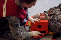 An Airman from the 8th Medical Group stabilizes a simulated gunshot victim for transport at the Wolf Pack Fitness Center, April 16, 2012. The 8th Fighter Wing is currently undergoing a Consolidated Unit Inspection with the Pacific Air Forces Inspector General team, who test the base’s ability to respond to crisis situations such as an active shooter. (U.S. Air Force photo/Senior Airman Jessica Hines) 