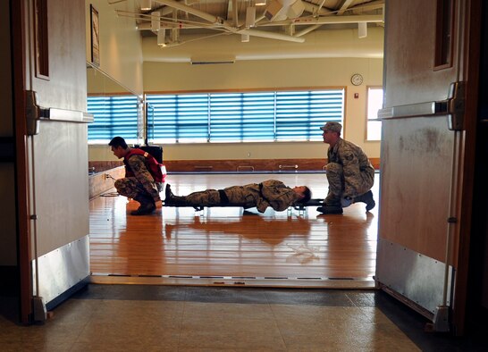 Airmen from the 8th Medical Group prepare to liter carry a simulated gunshot victim at the Wolf Pack Fitness Center, April 16, 2012. The 8th Fighter Wing conducted an emergency management scenario as part of an ongoing Pacific Air Force Inspector General Consolidated Unit Inspection. (U.S. Air Force photo/Senior Airman Jessica Hines) 