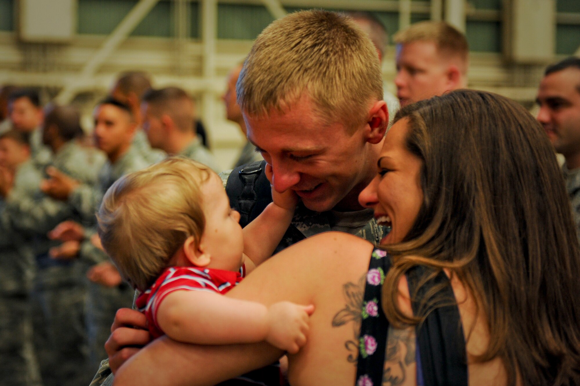 U.S. Air Force Senior Airman Michael Gryder, 18th Munitions Squadron, holds his family after returning from a deployment on Kadena Air Base, Japan, April 14, 2012. The welcome home celebration consisted of bouncy castles, movies and many excited smiles and tears for the reunited families. (U.S. Air Force photo by Airman 1st Class Brooke P. Beers/Released)