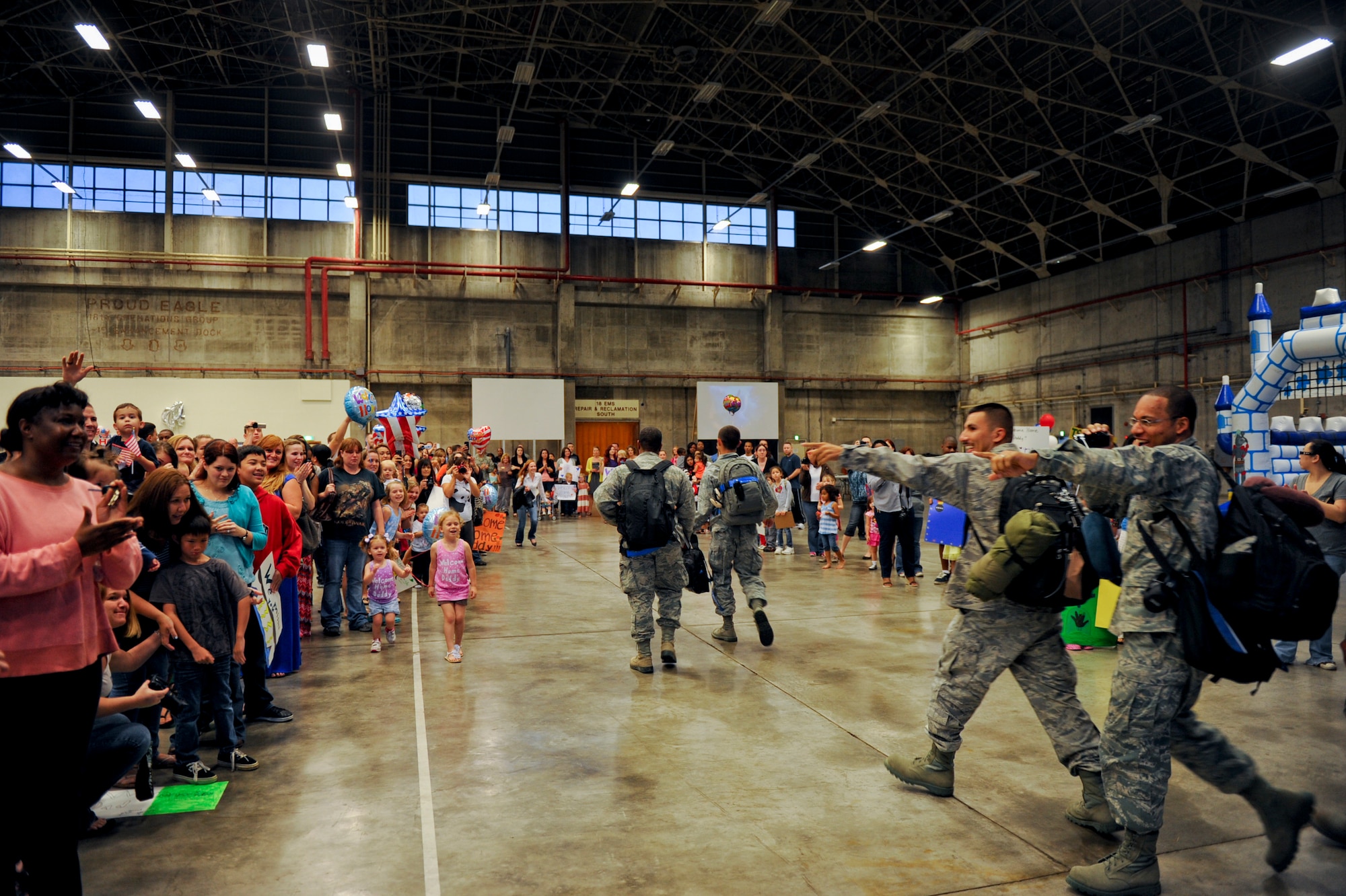 Airmen returning home from a deployment point out family members in the crowd during a welcome home celebration at Kadena Air Base, Japan, April 14, 2012. The Shogun warriors returned to their friends and families after being away for six months. (U.S. Air Force photo by Airman 1st Class Brooke P. Beers/Released)