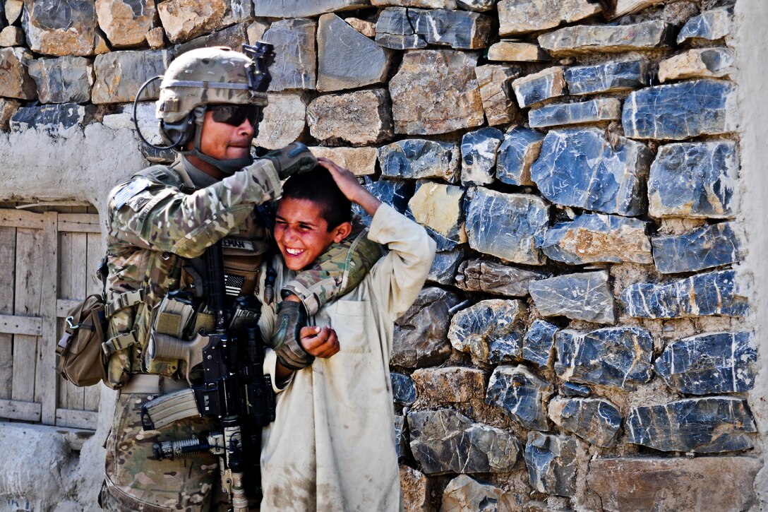 U.S. Army Staff Sgt. Christian Aleman gives a playful head rub to an Afghan child while on patrol on Forward Operating Base Salerno, Afghanistan, April 7, 2012. Aleman, a  squad leader, is assigned to A Battery, 2nd Battalion., 377th Parachute Field Artillery Regiment.