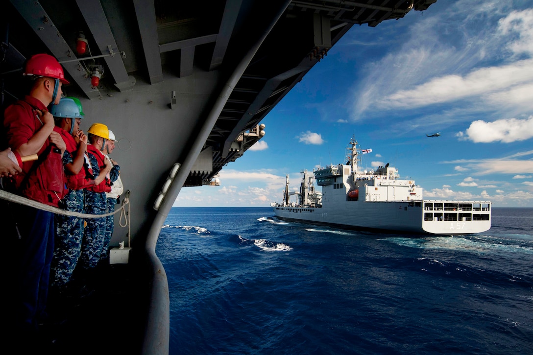 U.S. and Indian sailors watch the Indian navy replenishment oiler INS Shakti from the deck of the aircraft carrier USS Carl Vinson during a refueling exercise while under way in the Indian Ocean, April 13, 2012.