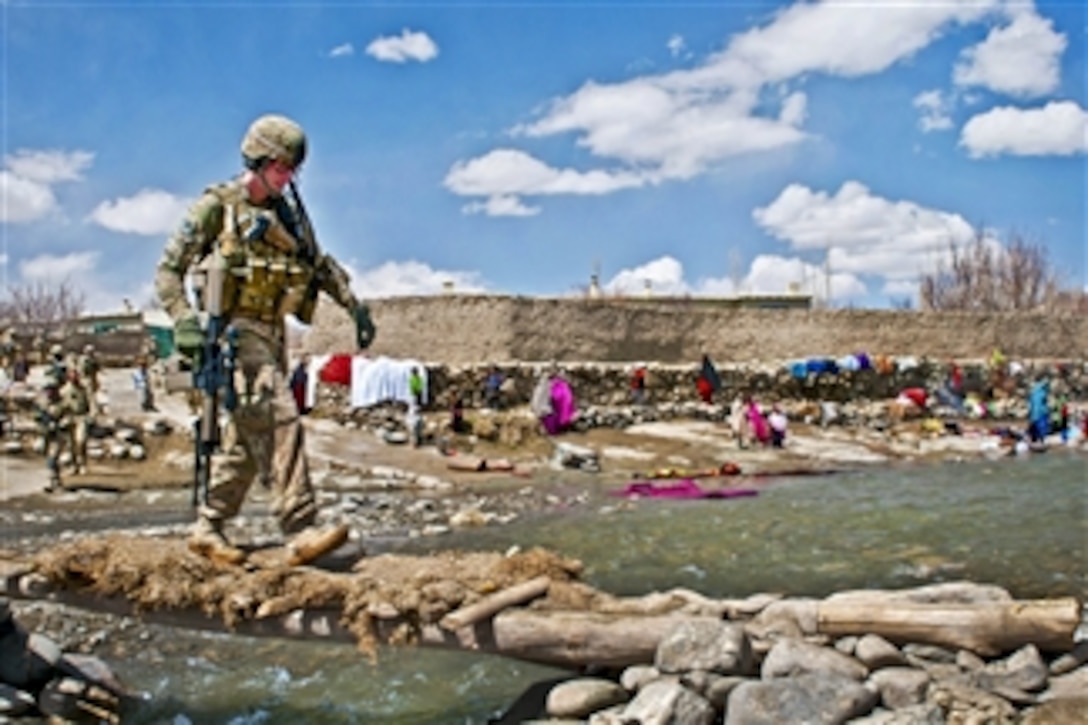 U.S. Army Sgt. Michael Trevino uses a foot bridge to cross a swollen river outside of the village of Marzak in Afghanistan's Paktika province on April 4, 2012.  Trevino is assigned to the 172nd Infantry Brigade.  