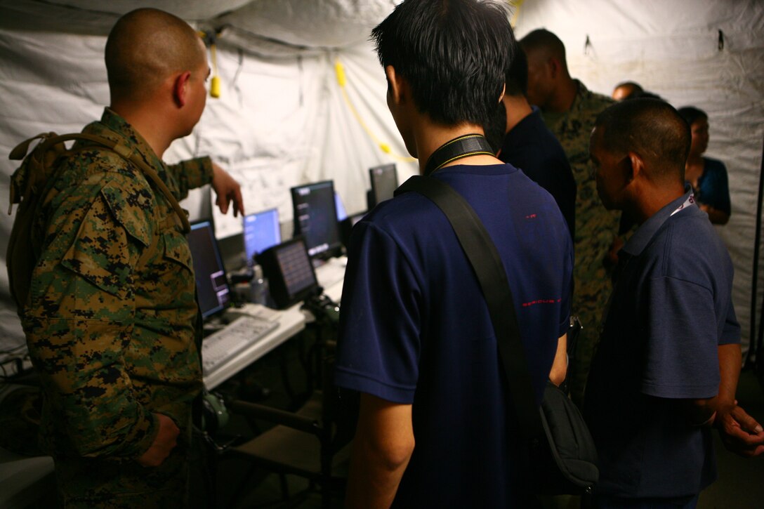 Jeffrey B. Migallos, center, and Enrique P. Morales, right, talk with Gunnery Sgt. Ricardo Clayton about air traffic control on Antonio Bautista Air Base on Puerto Princesa April 17, 2012. The career counterparts are jointly conducting air traffic control for the duration of Balikatan 2012 (BK12) Task Force Palawan. BK12 is a bilateral, joint exercise conducted annually between the U.S. and the Republic of the Philippines. This year marks the 28th iteration of the nations' exercise. Migallos and Morales are workers at the Puerto Princesa Airport. Clayton is the detachment air traffic control operations chief for Marine Air Control Squadron 4, Marine Air Control Group 18, 1st Marine Aircraft Wing, III Marine Expeditionary Force.