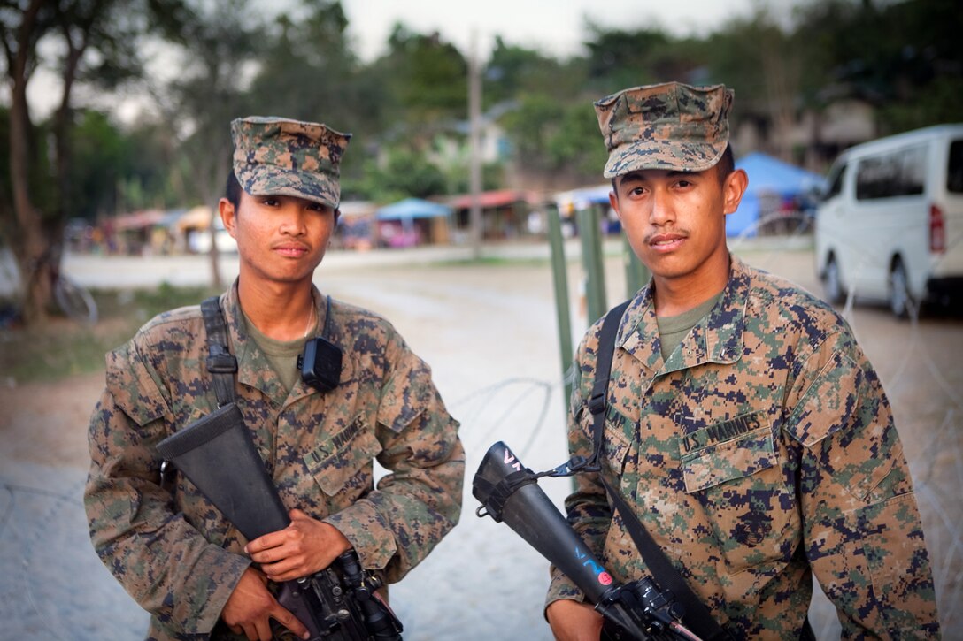 Lance Cpls. John L. Culilap (right), a field wireman with Combat Logistics Battalion 3, and Lance Cpl. Jed A. Delos-Reyes, a motor transportation operator with Headquarters Battalion, 3rd Marine Division, provide security at the camp at Crow Valley, during Balikatan 2012, April 17. Both Marines moved to California from the Philippines when they were young and have helped their unit by translating Tagalog for U.S. service members participating in the exercise.