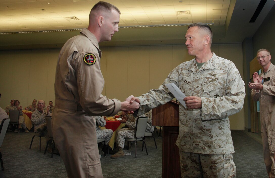Maj. Gen. Jon. M. Davis, right, commanding general of 2nd Marine Aircraft Wing, congratulates Maj. J. Eric Grunke, AV-8B Harrier pilot with Marine Attack Squadron 542, upon his recognition as the Marine Corps Aviator of the Year by the Marine Corps Aviation Association, during a luncheon at Miller's Landing officers' club aboard Marine Corps Air Station Cherry Point, April 17. Grunke was involved in a Tactical Recovery of Aircraft and Personnel mission in Libya in March 2011 to rescue the pilot of an Air Force F-15E that had crashed due to a mechanical failure. Over the course of the mission, Grunke dropped two 500-pound laser-guided bombs on tactical vehicles pursuing the pilot and identified a suitable landing zone for the MV-22B Osprey that would make the pickup.