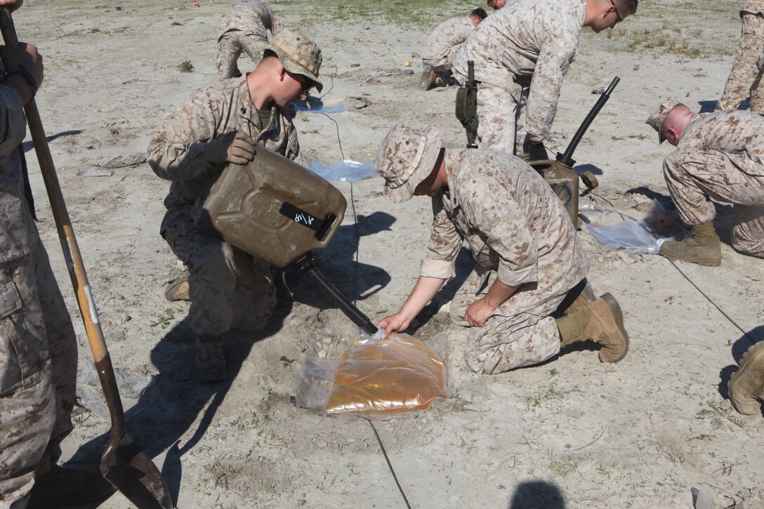 Explosive ordnance disposal Marines fill bags with diesel for an explosion demonstration April 17, 2012, at the EOD range aboard Marine Corps Air Station Cherry Point, N.C. EOD Marines plan to put on a big bang and ignite a 1,000 foot wall of fire for the 150,000 spectators expected at the Cherry Point air show May 4 - 6. Members of 2nd EOD Company, II Marine Expeditionary Force, based out of Camp Lejeune, will join the air station and 2nd Marine Aircraft Wing EOD Marines to assist during this year’s air show.