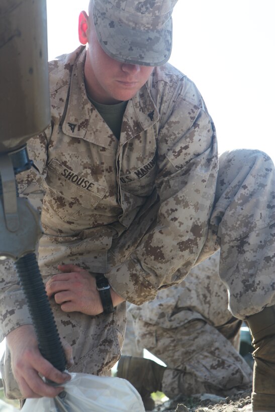 Lance Cpl. David S. Shouse, a supply clerk with Headquarters and Headquarters Squadron, assists explosive ordnance disposal Marines by filling bags with diesel fuel for an explosion demonstration at the EOD range aboard Marine Corps Air Station Cherry Point, April 17, 2012. The Marines executed a down-sized practice run creating a 30-foot wall of fire and detonating other explosives at the station ordnance disposal range.