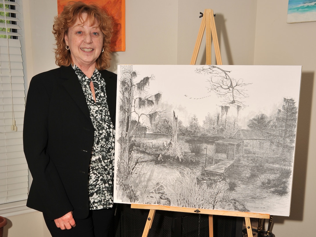 Dawn Humphreys, the administrative program coordinator for Headquarters 8th Marine Corps District shows off one of her most prized pen-and-ink drawings April 17, 2012, at her home in Fort Worth, Texas. Humphreys handles civilian payroll, retirement resources and issues on an individual basis by day, but spends her free time painting and drawing works of art.