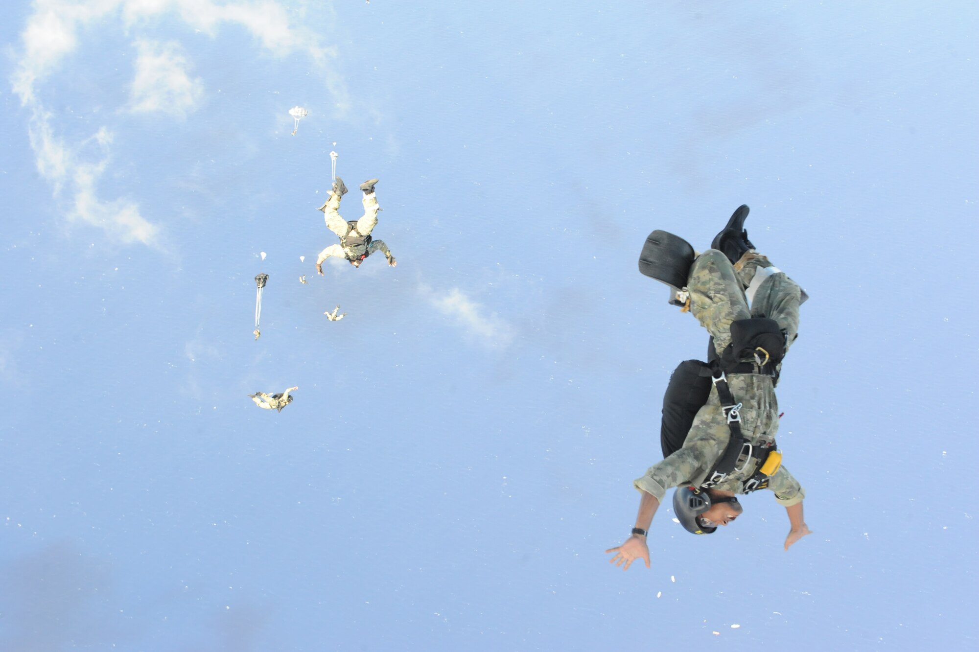 International military members jump out the back of a C-17 Globemaster III from the 535th Airlift Squadron at Joint Base Pearl Harbor Hickam, Hawaii, April 9 after a boat dropped right before him over the ocean surrounding Naval Base Guam during a five-day mission to fly, execute airdrops, and foster joint service and international operability in the Pacific theater. During the mission, the aircrew dropped static-line personnel, heavy equipment platforms, high-velocity container delivery system bundles, low-velocity CDS bundles, and High-Altitude Low-Opening jumpers during their time in Guam. (U.S. Air Force photo by Staff Sgt. Nathan Allen)