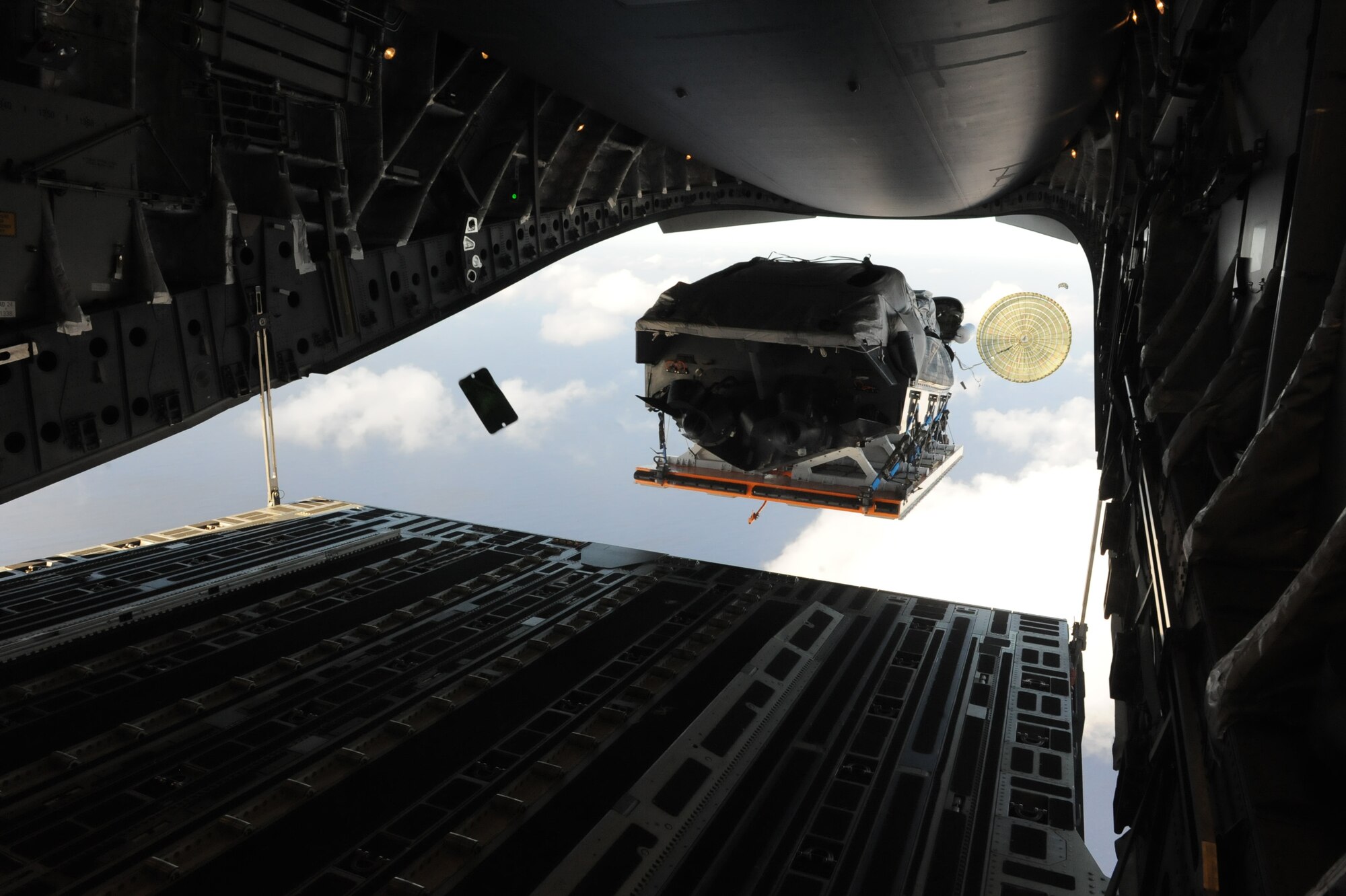 A boat flies out the back of a C-17 Globemaster III from the 535th Airlift Squadron at Joint Base Pearl Harbor Hickam, Hawaii, April 9 over the ocean surrounding Naval Base Guam during a five-day mission to fly, execute airdrops, and foster joint service and international operability in the Pacific theater. During the mission, the aircrew dropped static-line personnel, heavy equipment platforms, high-velocity container delivery system bundles, low-velocity CDS bundles, and High-Altitude Low-Opening jumpers during their time in Guam. (U.S. Air Force photo by Staff Sgt. Nathan Allen)