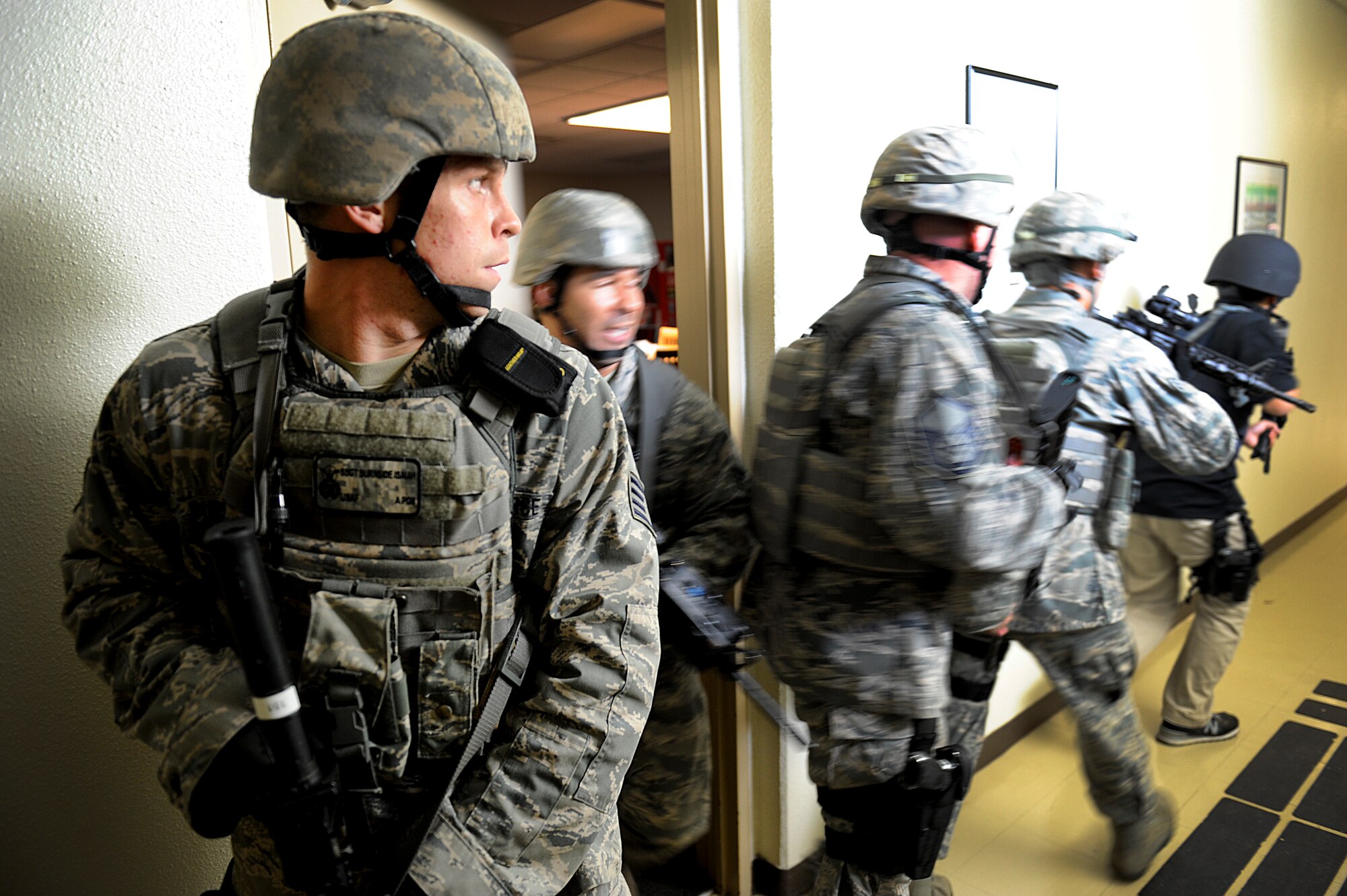 U.S. Air Force Staff Sgt. Isaiah Burnside, 18th Security Forces Squadron response force leader, stands guard as his team exits a classroom at Kadena High School during a Pacific Air Forces High-Risk Response Training active-shooter scenario on Kadena Air Base, Japan, April 12, 2012. During the training, service members from around the base volunteered as "victims" to give the scenario realism. (U.S. Air Force photo by Airman 1st Class Maeson L. Elleman/Released)
