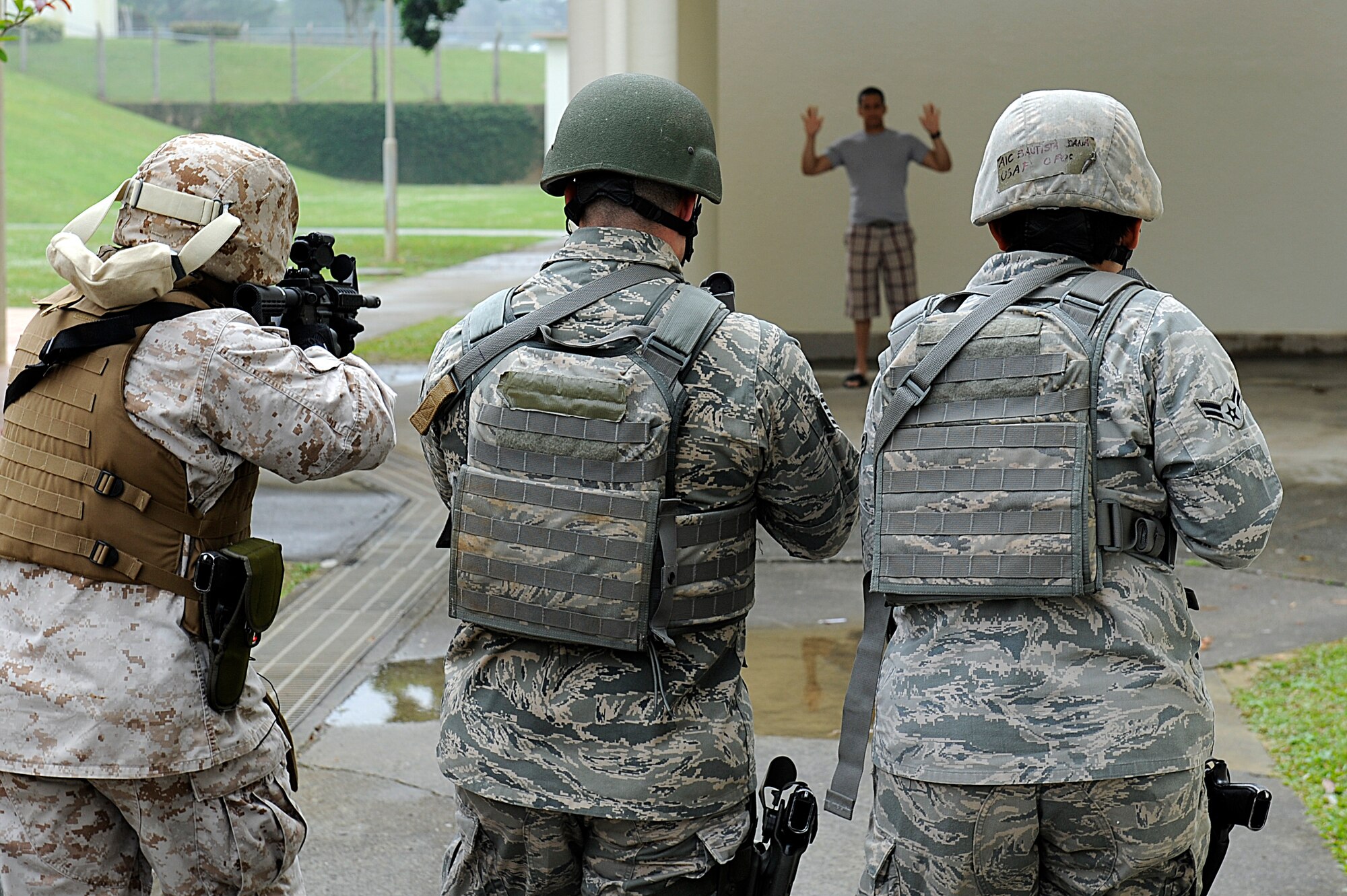 (From left to right) U.S. Marine Corps 1st Sgt. Fernando Ascencio, U.S. Air Force Staff Sgt. Jason Barracato and Airman 1st Class Joana Bautista, all members from the Pacific Air Forces High-Risk Response Training Team One, investigate a potential suspect at Kadena High School during an active-shooter scenario on Kadena Air Base, Japan, April 12, 2012. During the scenario, members from the different teams took turns clearing the school in search of potential gunmen. (U.S. Air Force photo by Airman 1st Class Maeson L. Elleman/Released)