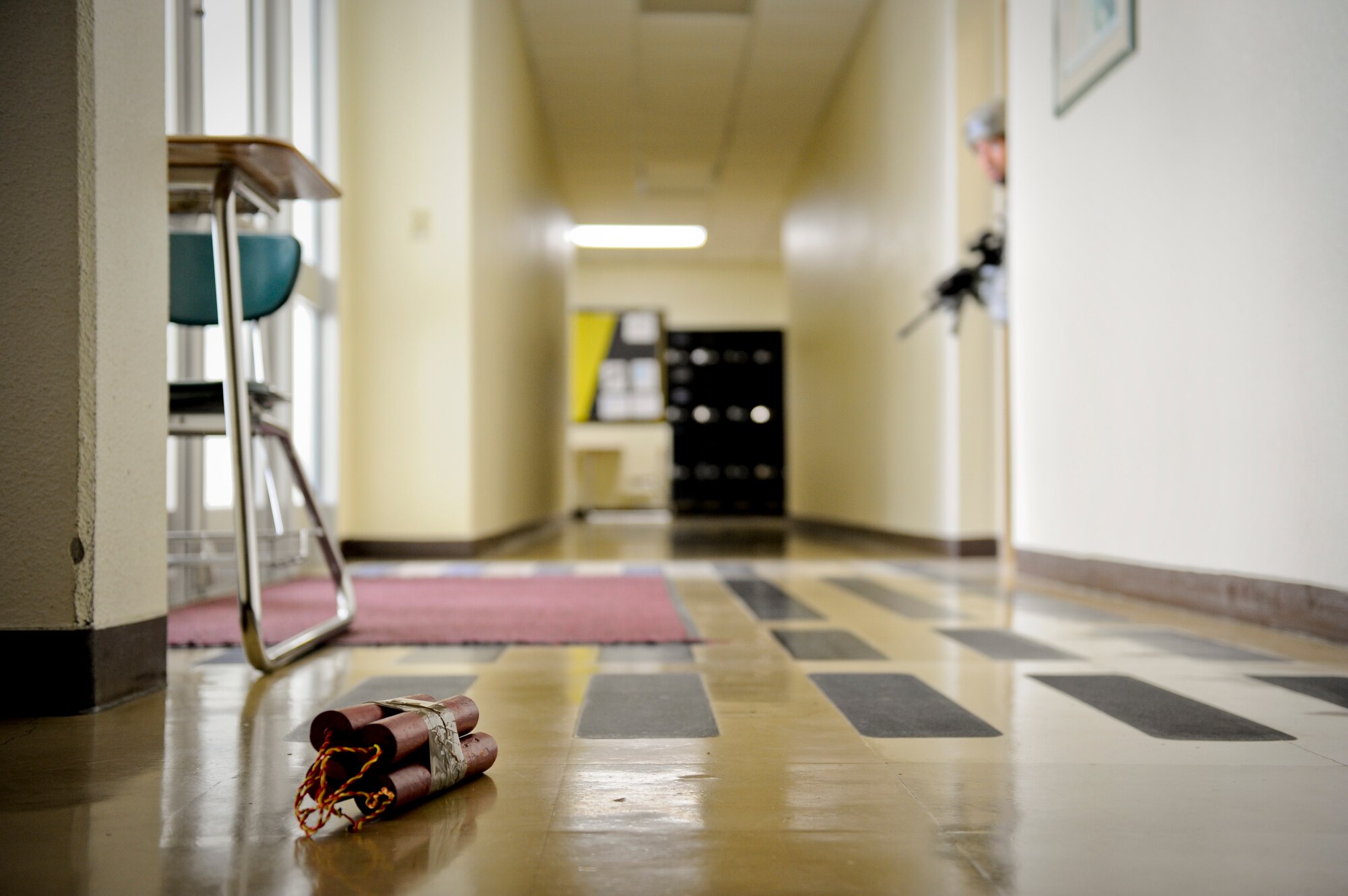 An 18th Security Forces Squadron response force member peeks around a corner at an improvised explosive device during a Pacific Air Forces High-Risk Response Training active-shooter scenario on Kadena Air Base, Japan, April 12, 2012. Military police members from each of the U.S. Armed Services as well as their civilian counterparts participated in the five-day training program. (U.S. Air Force photo by Airman 1st Class Maeson L. Elleman/Released)