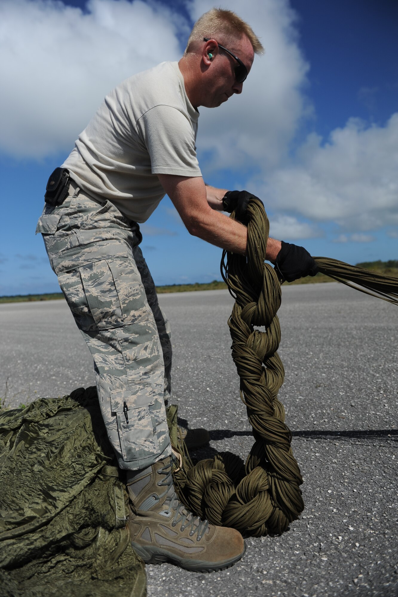 Master Sgt. Jon Callaway, 647th Logistics Readiness Squadron combat mobility flight chief from Joint Base Pearl Harbor Hickam, Hawaii, uses the “daisy chain” technique to field pack a parachute after it was used to drop a heavy equipment platform from a C-17 Globemaster III April 6 at the drop zone on Andersen Air Force Base, Guam during a five-day mission to fly, execute airdrops, and foster joint service and international operability in the Pacific theater. During the mission, the aircrew dropped static-line personnel, heavy equipment platforms, high-velocity container delivery system bundles, low-velocity CDS bundles, and High-Altitude Low-Opening jumpers during their time in Guam. (U.S. Air Force photo by Staff Sgt. Nathan Allen)