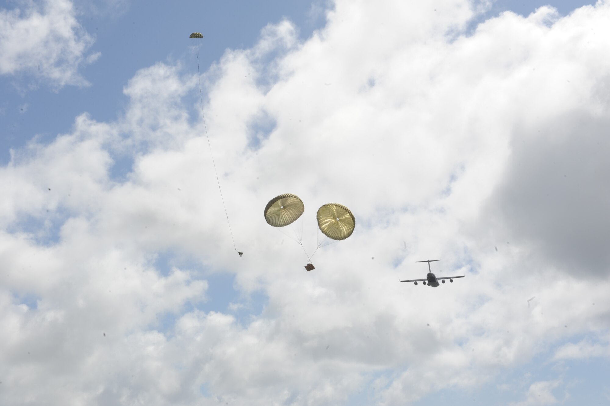 A C-17 Globemaster III from the 535th Airlift Squadron at Joint Base Pearl Harbor Hickam, Hawaii, drops a heavy equipment platform April 6 over the drop zone at Andersen Air Force Base, Guam during a five-day mission to fly, execute airdrops, and foster joint service and international operability in the Pacific theater. During the mission, the aircrew dropped static-line personnel, heavy equipment platforms, high-velocity container delivery system bundles, low-velocity CDS bundles, and High-Altitude Low-Opening jumpers during their time in Guam. (U.S. Air Force photo by Staff Sgt. Nathan Allen)