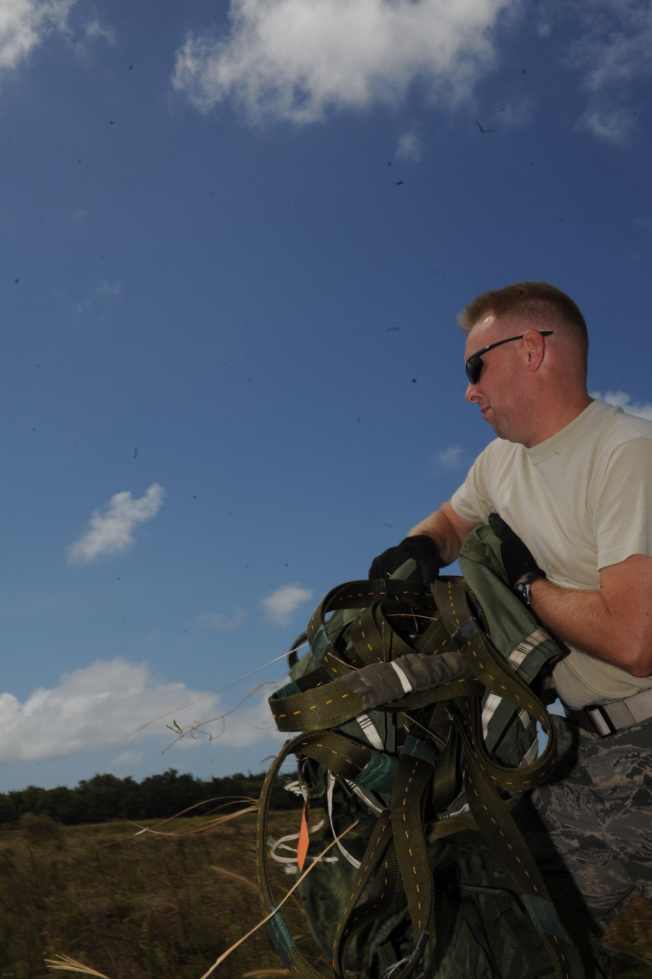 Master Sgt. Jon Callaway, 647th Logistics Readiness Squadron combat mobility flight chief from Joint Base Pearl Harbor Hickam, Hawaii, recovers parachutes from heavy equipment platform April 6 after they were dropped from a 15th Wing C-17 Globemaster III at the drop zone on Andersen Air Force Base, Guam during a five-day mission to fly, execute airdrops, and foster joint service and international operability in the Pacific theater. During the mission, the aircrew dropped static-line personnel, heavy equipment platforms, high-velocity container delivery system bundles, low-velocity CDS bundles, and High-Altitude Low-Opening jumpers during their time in Guam. (U.S. Air Force photo by Staff Sgt. Nathan Allen)
