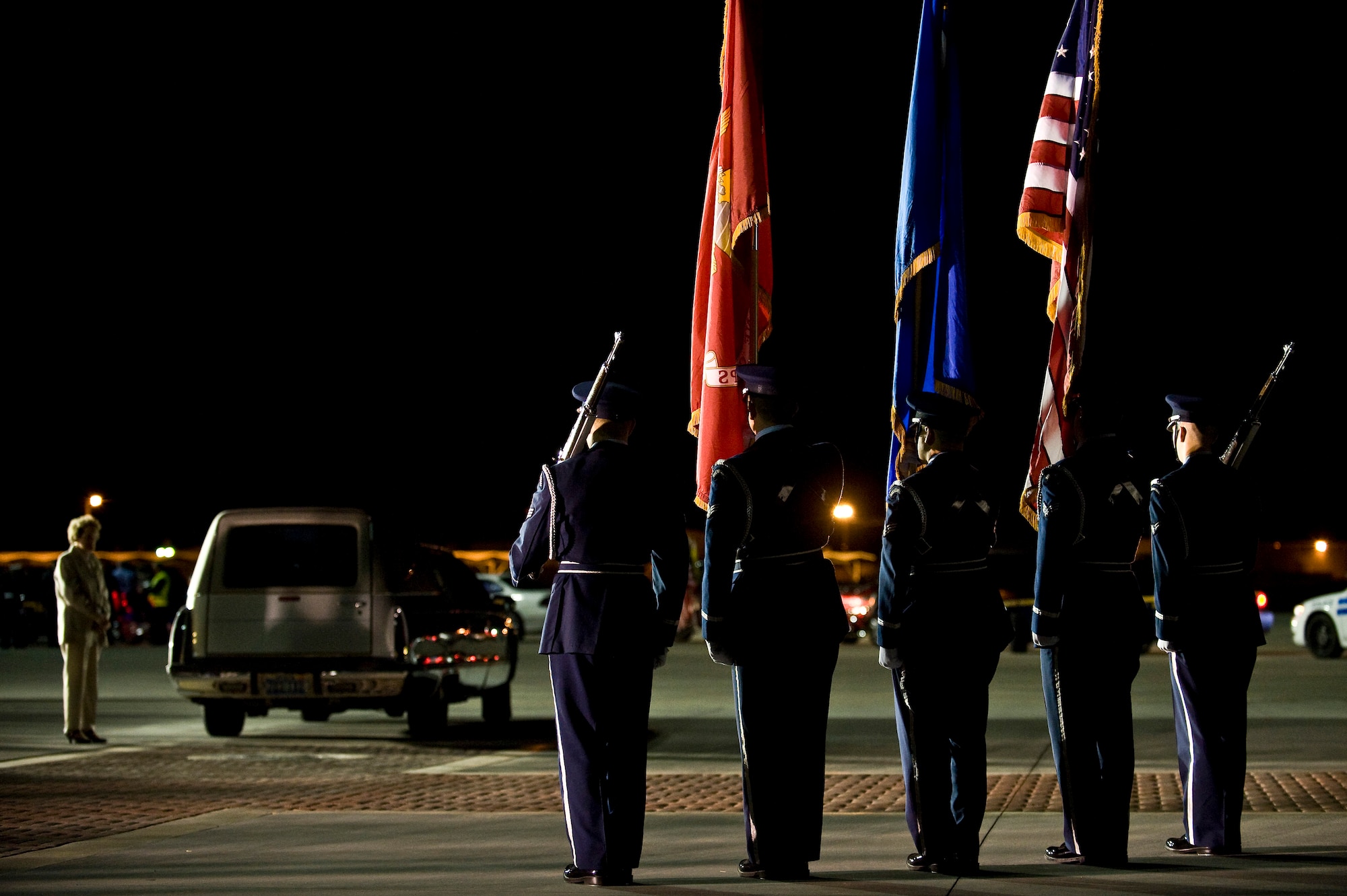 The Nellis Air Force Base Honor Guard watches a hearse transporting a fallen servicemember during a dignified transfer ceremony Jan. 25, 2011, on the flightline at Nellis Air Force Base, Nev. The Nellis Honor Guard will be reduced in size and will focus more closely on its core mission, providing military funeral honors. (U.S. Air Force photo by Senior Airman Brett Clashman)
