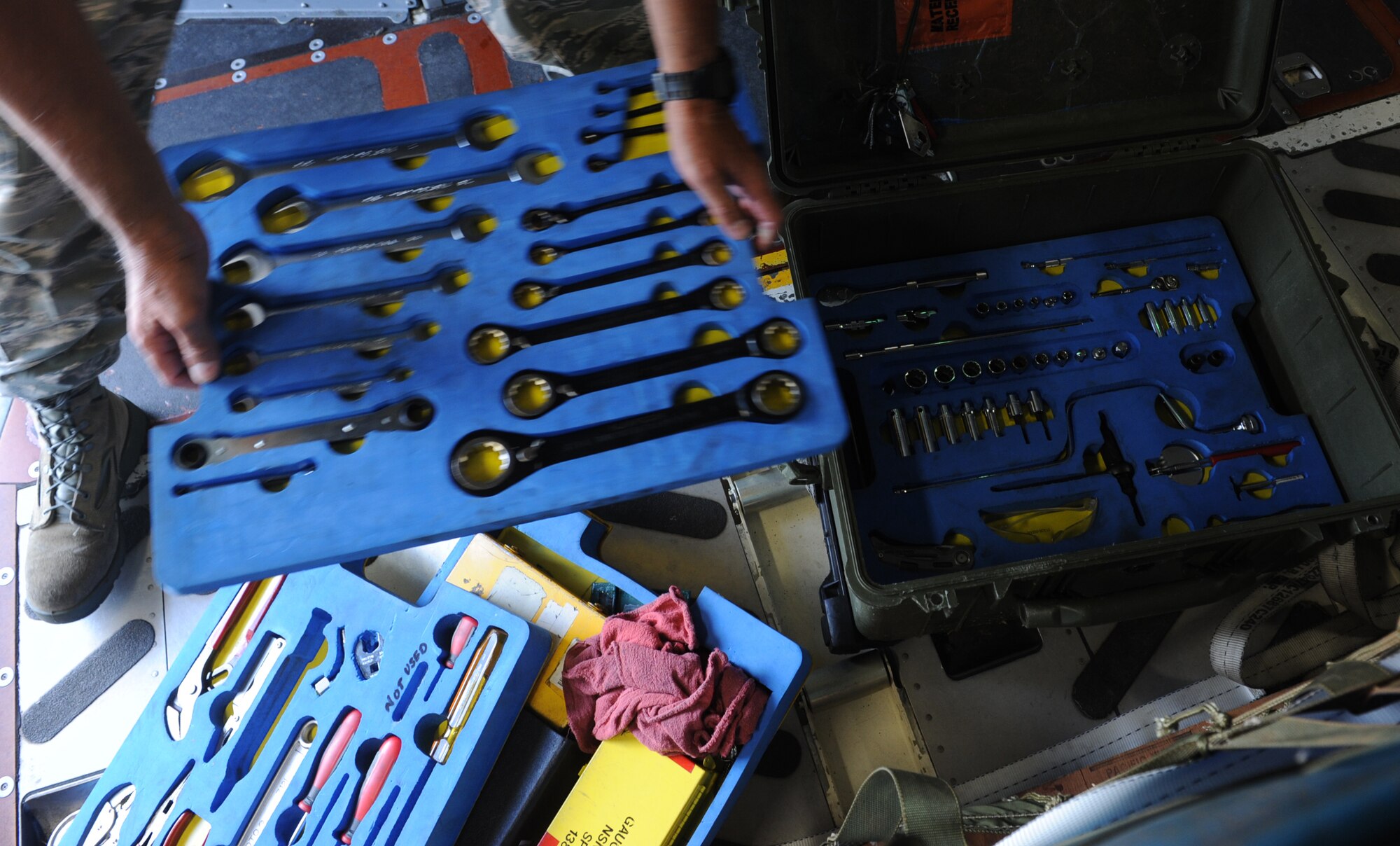 Tech. Sgt. Miles Nakamura, 154th Aircraft Maintenance Squadron flying crew chief, sorts through an assortment of tools while performing pre-flight maintenance on a C-17 Globemaster III from the 535th Airlift Squadron at Joint Base Pearl Harbor Hickam, Hawaii, April 6 at Andersen Air Force Base, Guam, while on a five-day mission to fly, execute airdrops, and foster joint service and international operability in the Pacific theater. During the mission, the aircrew dropped static-line personnel, heavy equipment platforms, high-velocity container delivery system bundles, low-velocity CDS bundles, and High-Altitude Low-Opening jumpers during their time in Guam. (U.S. Air Force photo by Staff Sgt. Nathan Allen)
