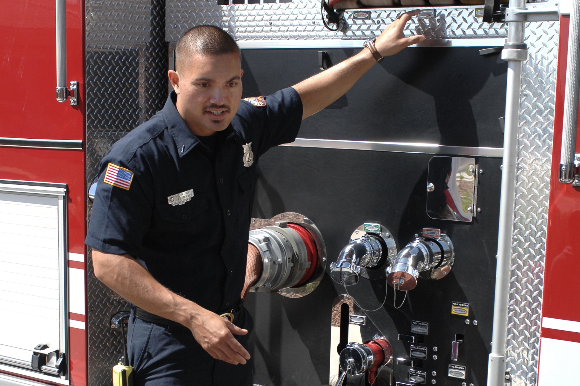 Kevin Smith, 99th Civil Engineer Squadron fire fighter, shows children the many features on a fire truck at the Child Development Center, April 10, 2012, at Nellis Air Force Base, Nev.  The firemen educated children and adults about the fire department and fire safety during the community day visit.  (U.S. Air Force photo by Senior Airman Jack Sanders)
  

