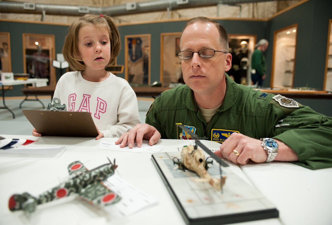 Col. Mark Weatherington, 28th Bomb Wing commander, and his 6-year-old daughter, Natalie, inspect a scale model Huey helicopter during the scale model contest at the South Dakota Air and Space Museum in Box Elder, S.D., April 14, 2012. Weatherington was one of several judges who scored the aviation section of the contest. Entries were graded on detail, paint scheme, and overall construction. (U.S. Air Force photo by Airman 1st Class Kate Thornton/Released)
