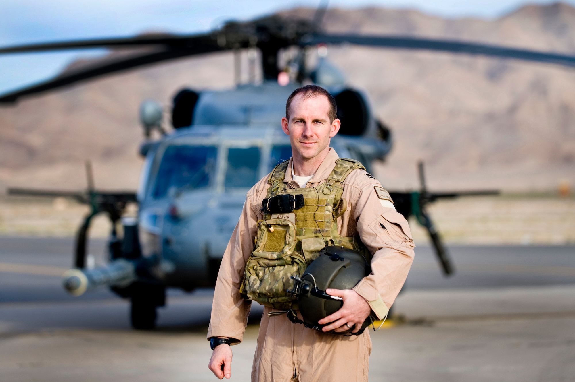 U.S. Air Force Capt. Kevin Weaver, 66th Rescue Squadron helicopter pilot, stands next to a HH-60 Pavehawk helicopter, April 12, 2012, at Nellis Air Force, Nev. Capt Weaver was awarded the Distinguished Flying Cross with valor for combat actions while deployed to Afghanistan. In the Watapur Valley, Afghanistan, Capt. Weaver took intensive machine gun and rocket propelled grenade fire while performing a precision hover and hoist to evacuate eleven casualties. While under fire, Capt. Weaver directed OH-58 and AH-64 weapons teams to engage three enemy positions, suppressing the threats and ensuring the successful delivery of pararescuemen. (U.S. Air Force photo by Staff Sgt. William P.Coleman)
  

