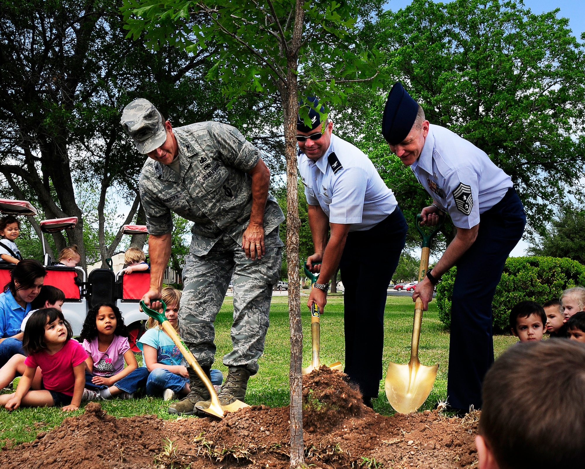 GOODFELLOW AIR FORCE BASE, Texas -- Col. Mark Damiano (center), 17th Training Wing Commander, Col. Paul Bugenske, 17th Mission Support Group
Commander, and Chief Master Sgt. Scott Lumpkin, 17th TRW Command Chief, plant a tree with the children at the Child Development Center April 16.  The event taught the children the importance of trees in our environment, while celebrating Earth Day and Environmental Awareness Week.  (U.S. Air Force photo/Staff Sgt. Austin Knox)    
