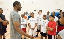 A.J. English, former National Basketball Association player for the Washington Bullets, talks to members of the Dover Air Force Base, Del., Youth Center during a basketball skills development clinic at the Youth Center April 11, 2012, at Dover AFB. Alvin Jackson, director of 100% Tobacco-Free Sports, uses the popularity of basketball to motivate youth to stay away from tobacco, drugs and alcohol. A.J. English, conducted the clinic. (U.S. Air Force photo by Roland Balik)