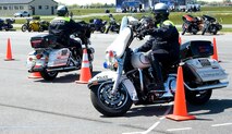 Members of the Dover, Del., Police Department maneuver their motorcycles through cones April 13, 2012, during Motorcycle Safety Day at Dover Air Force Base, Del. Motorcycle Safety Day is a yearly event held to ensure riders and motorists are aware of increased safety measures while riding. (U.S. Air Force photo by Adrian R. Rowan)