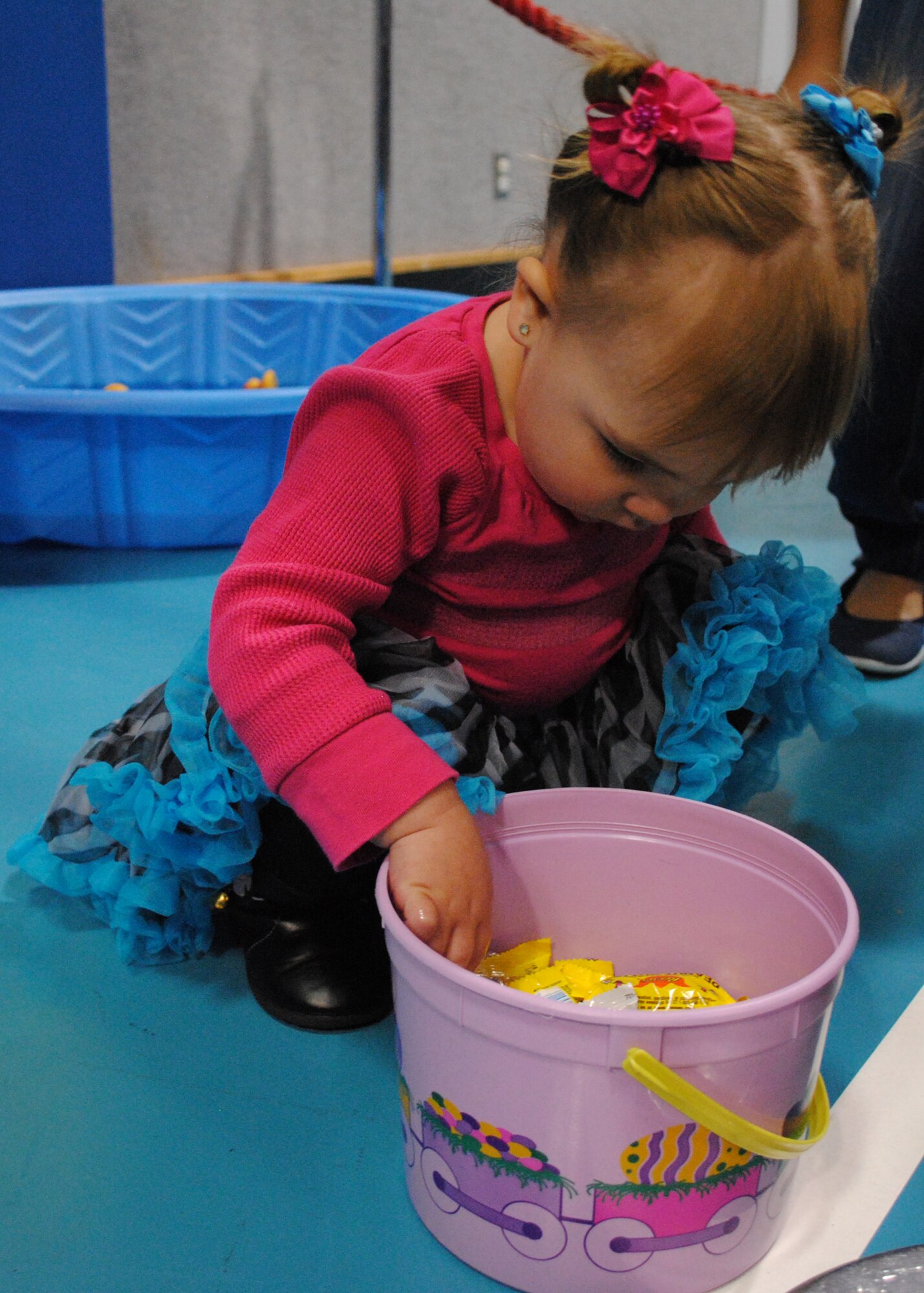 Isabella Geike, 2, reaches for a piece of candy after playing a game in the duck pond. (U.S. Air Force photo/Airman 1st Class Katrina Heikkinen)