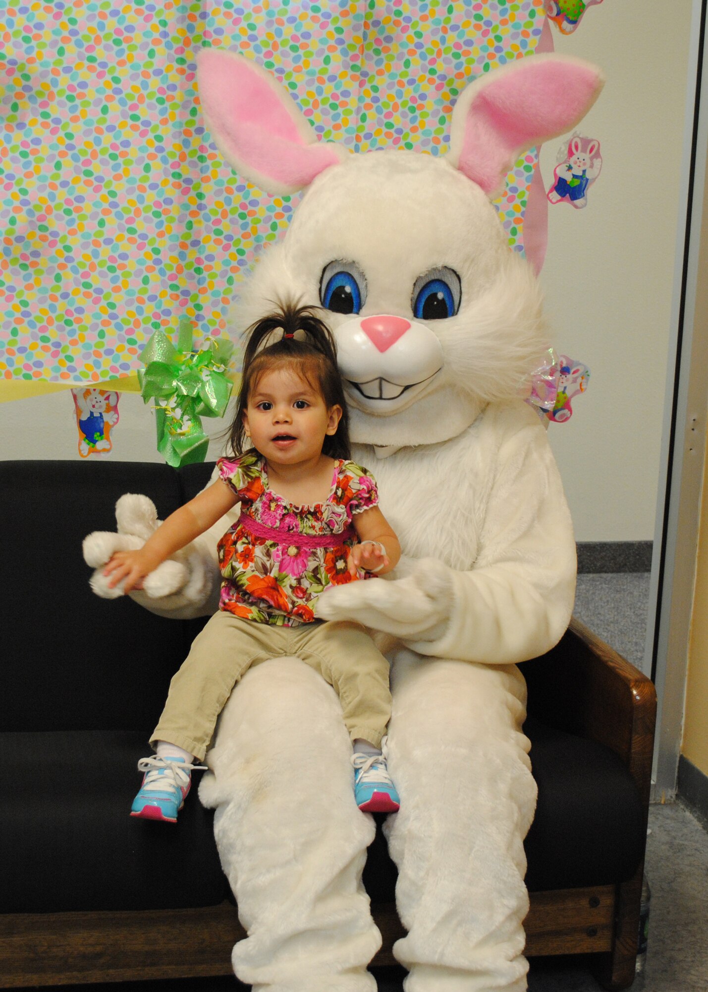 Dalilah Cortez, 21 months, sits on the Easter bunny's lap during the Spring Carnival. Games, candy, food and prizes were available at the annual event. (U.S. Air Force photo/Airman 1st Class Katrina Heikkinen)
