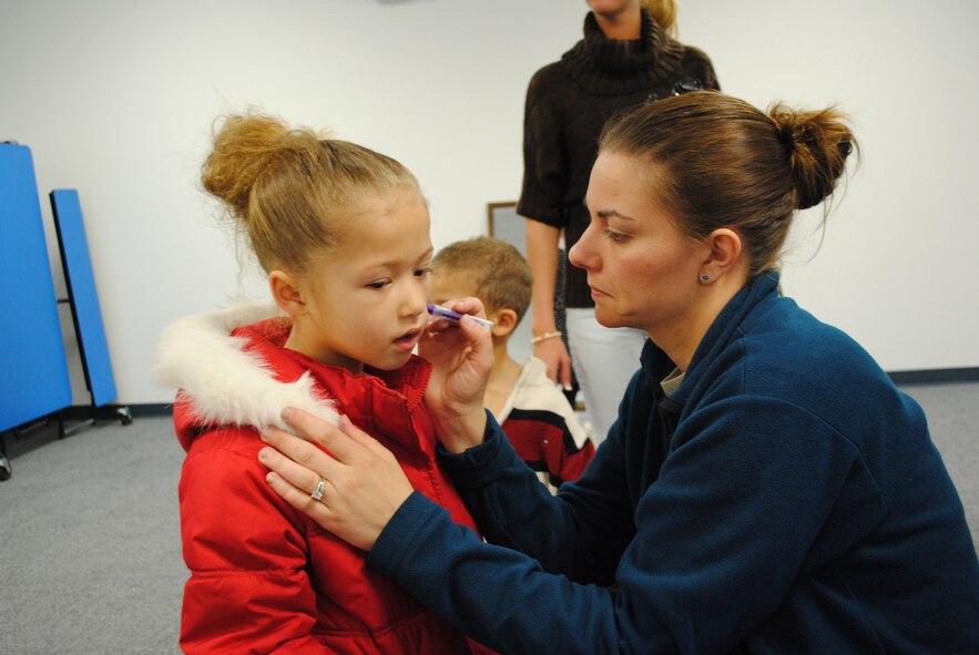 Kailey Smith, 5, waits patiently as Amber Gardner paints a unicorn on her face during the annual Spring Carnival at the Youth Center April 7. (U.S. Air Force photo/Airman 1st Class Katrina Heikkinen)