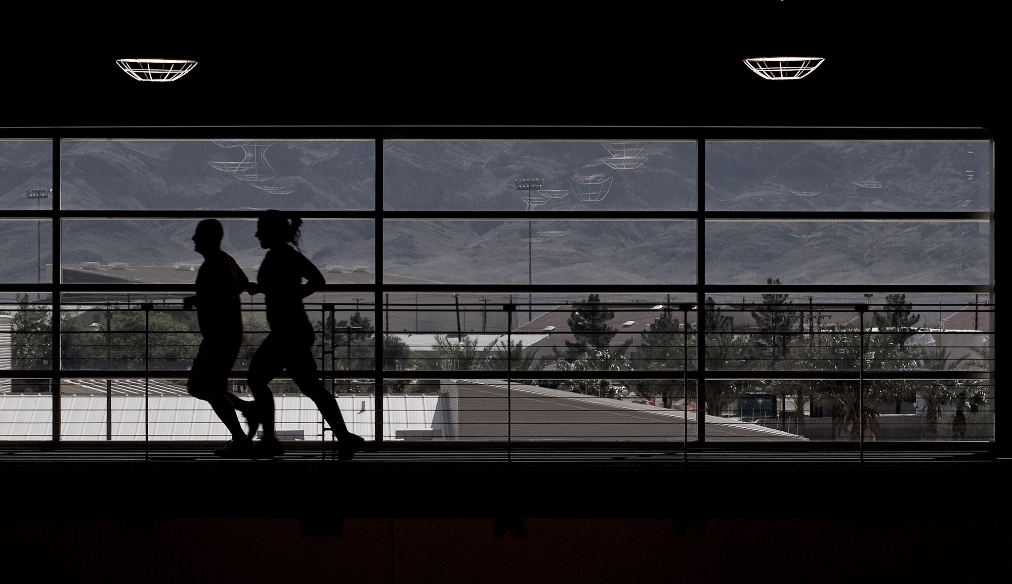 The eighth-mile running track allows Airmen and dependents to work out in a temperature-controlled environment at the Warrior Fitness Center April 12, 2012, at Nellis Air Force Base, Nev. Specially coated windows in the Warrior Fitness Center block ultraviolet rays in sunlight from entering the gym and creating excess heat, greatly reducing the energy needed for cooling. The gym's windows are placed so that they receive the least possible amount of direct UV rays, while special exterior facing materials and insulation passively cool the building without using additional energy. (U.S. Air Force photo by Staff Sgt. Christopher Hubenthal)