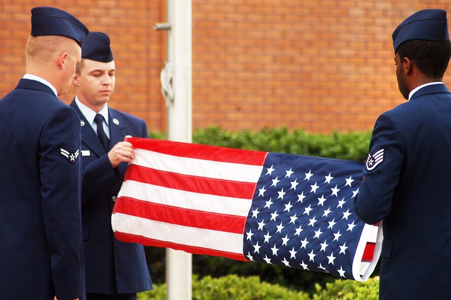 L-R, Airman 1st Class Tyler Bowen, Senior Airman Clayton Leirer and Staff Sgt. Maurice Collins fold the flag during a retreat cermony by the 78th Mission Support Group in honor of the retirement of Chief Master Sgt. Eric R. Jaren, Headquarters  Air Force Materiel Command command chief. (U. S. Air Force photo by Sue Sapp)