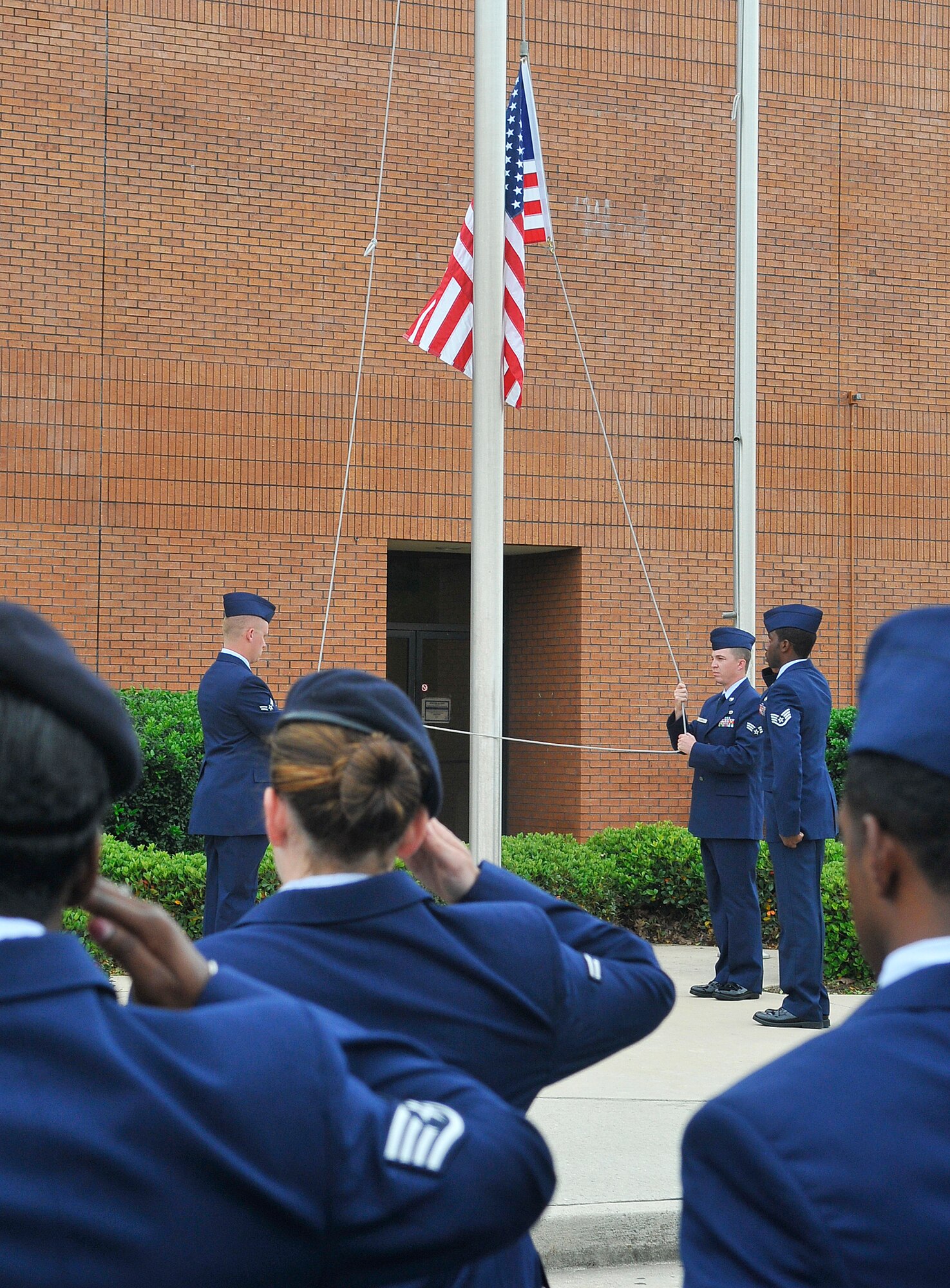 L-R, Airman 1st Class Tyler Bowen, Senior Airman Clayton Leirer and Staff Sgt. Maurice Collins lower the flag during a retreat cermony by the 78th Mission Support Group in honor of the retirement of Chief Master Sgt. Eric R. Jaren, Headquarters  Air Force Materiel Command command chief. (U. S. Air Force photo by Sue Sapp)