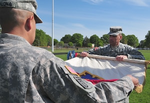 Col. Lawrence Kominaik, 7th Sustainment Brigade commander, unfurls the brigade’s colors during a Transfer of Authority ceremony held at Fort Eustis’ Murphy Field April 13. Kominiak returned from a year-long deployment to Afghanistan to resume command, as the provisional commander, Col. Stephen Cherry, departed. (U.S. Army photo by Sgt. Edwin Rodriguez/Released)