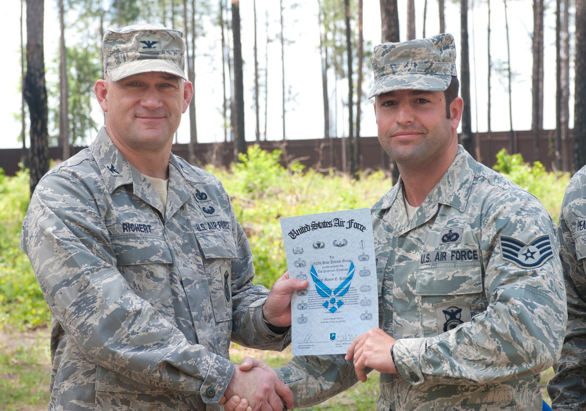 U.S. Air Force Staff Sgt. Moses Palermo, 822nd Base Defense Squadron, receives a graduation certificate from Col. Randall Richert, 820th Base Defense Group commander, at Moody Air Force Base, Ga., April 13, 2012. Palermo was recognized as the top performer for 2nd Squad. (U.S. Air Force photo by Airman 1st Class Jarrod Grammel/Released)
