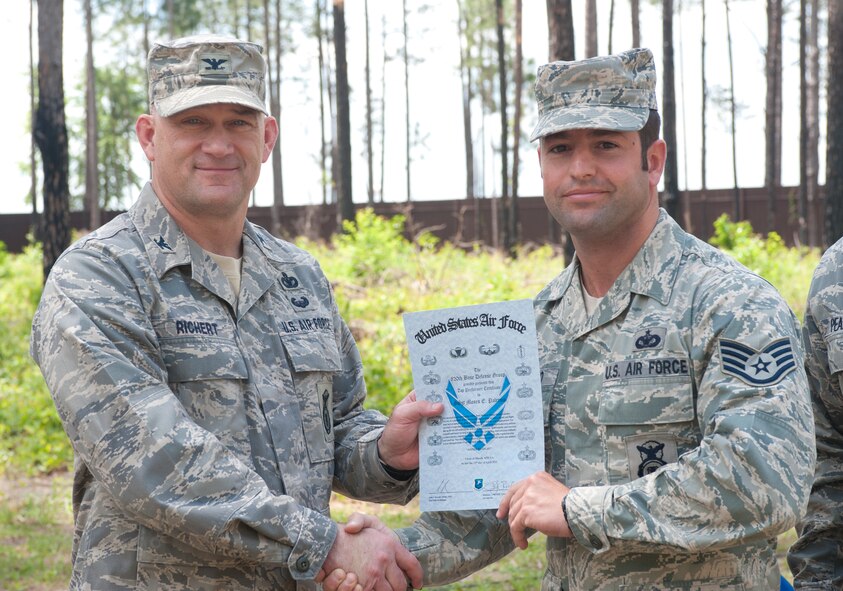 U.S. Air Force Staff Sgt. Moses Palermo, 822nd Base Defense Squadron, receives a graduation certificate from Col. Randall Richert, 820th Base Defense Group commander, at Moody Air Force Base, Ga., April 13, 2012. Palermo was recognized as the top performer for 2nd Squad. (U.S. Air Force photo by Airman 1st Class Jarrod Grammel/Released)
