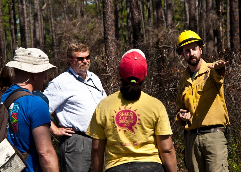 Brett Williams, 96th Civil Engineer Group fire ecologist with Jackson Guard, explains how the forests in and around Eglin reservation are “fire dependant” ecosystems, April 17.  According to Williams, the forest requires fire every three years to maintain a sustainable habitat for the indigenous wildlife and vegetation. Many native plants and animal species depend on Eglin's fire-dependent long-leaf pine ecosystem, 11 of which are federally protected. Endangered species such as the red-cockaded woodpecker, depend on fire that is typically caused by either lightning strikes or Eglin's resident fire managers to survive. The display was part of a walking “eco-tour” on Eglin reservation near White Point in celebration of Eglin’s Earth Week. (U.S. Air Force photo/Samuel King Jr.)