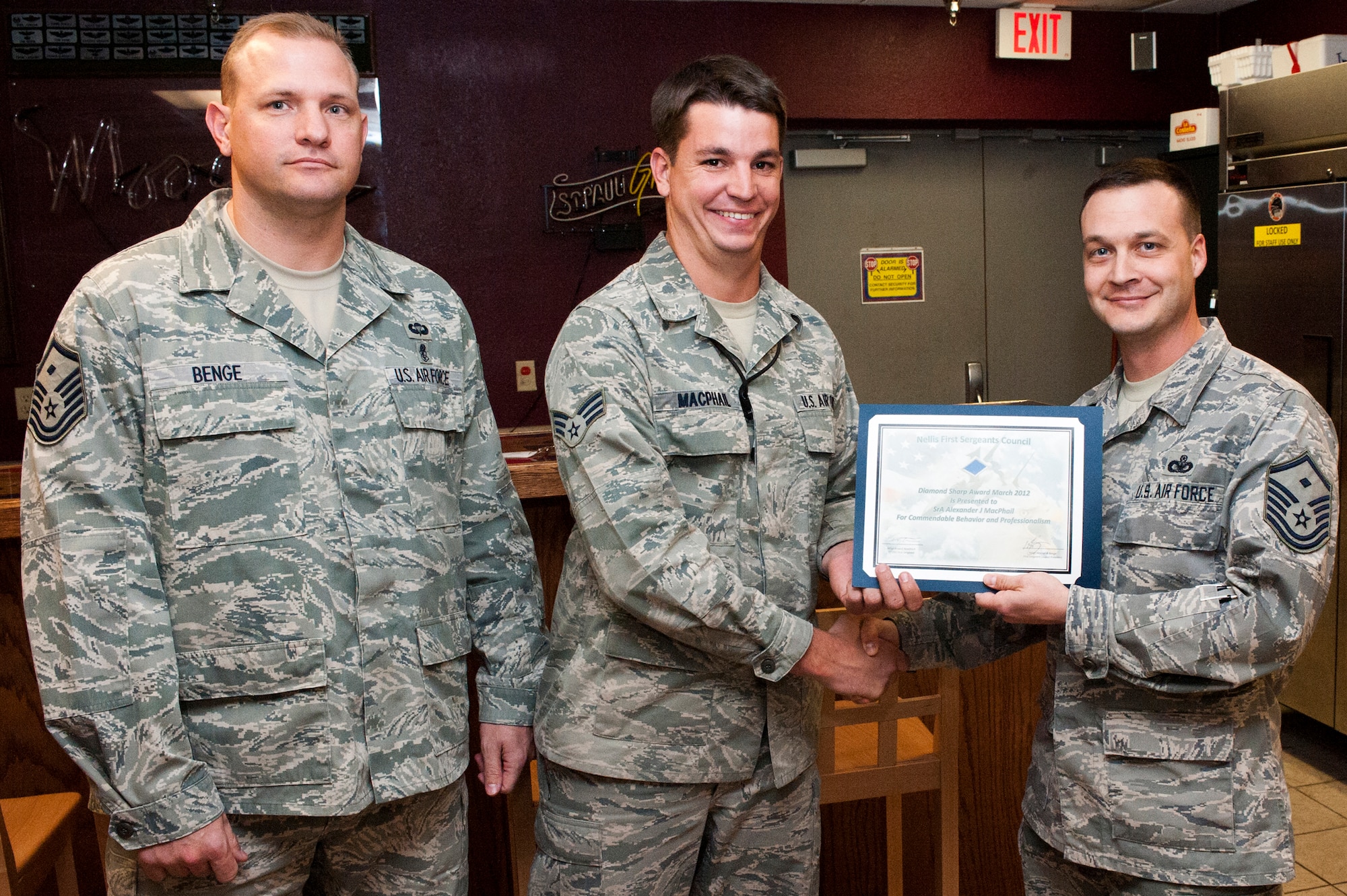 (Left to right) U.S. Air Force Master Sgt. Warren Benge, 57th Aircraft Maintenance Squadron first sergeant, Senior Airman Alexander MacPhail, 414th Combat Training Squadron system administrator, and Master Sgt. Brian Noethlich, 57th Operations Support Squadron first sergeant pose for the presentation of the first ever Diamond Sharp Award presentation April 5, 2012, at Nellis Air Force Base, Nev.

The First Sergeant's Diamond Sharp Award is designed to recognize an individual who truly stands out with abilities, sheer drive and characteristic traits most others do not possess. MacPhail was presented the award when he and his team installed the Microsoft Windows 7 operating system on 200 computers within three days and verified vital Integrated Maintenance Data System connectivity to 12 hangars in support of over 1000 Red Flag 12-3 missions flown. (U.S. Air Force photo by Airman 1st Class Jason Couillard)