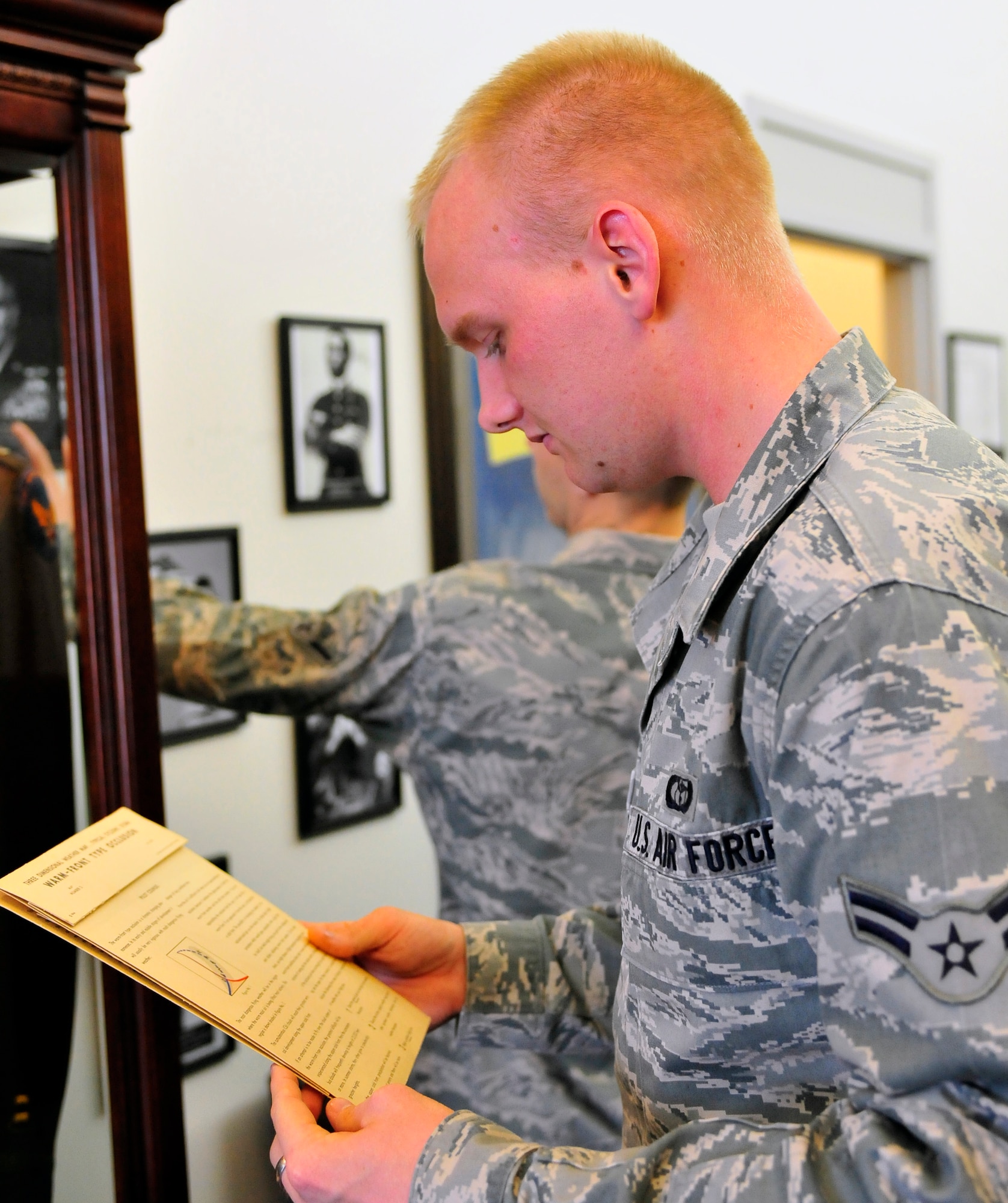 Airman 1st Class Matthew Toney, 28th Operational Weather Squadron forecaster, looks over an old weather map in the 28th OWS lobby, Shaw Air Force Base, S.C., April 6, 2012. Volunteers from the 28th OWS created an Air Force memorabilia display in their lobby to help squadron members and visitors gain a sense of pride in their heritage. (U.S. Air Force photo by Senior Airman Daniel Phelps/Released)
