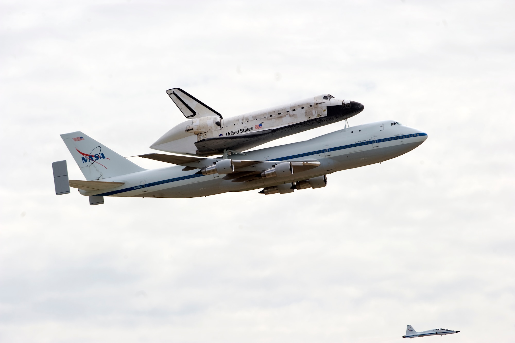 a NASA Shuttle Carrier aircraft carrying the space shuttle Discovery flies above Joint Base Andrews with a NASA chase plane escort April 17.  The retired shuttle landed at the Washington Dulles International Airport for delivery to the National Air & Space Museum’s Udvar-Hazy Center.  (Photo/Bobby Jones) 
